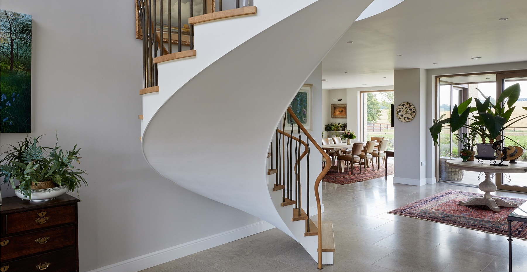 Statement staircase project with modern oak treads around a floating helical staircase structure